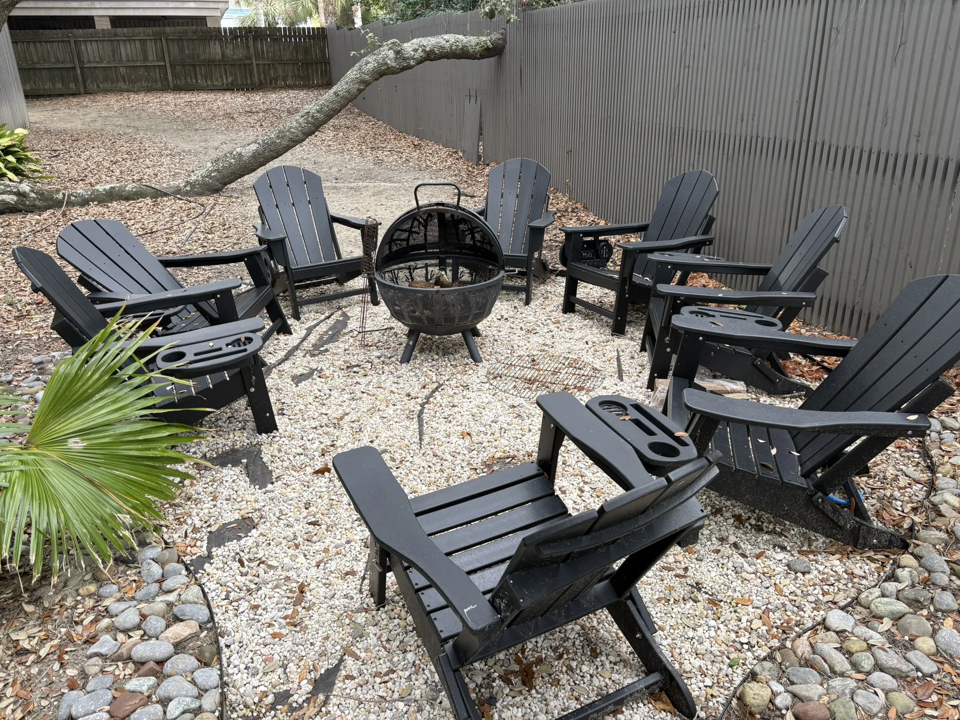 Evening fire pit gathering area under live oaks with crushed oyster shell surround