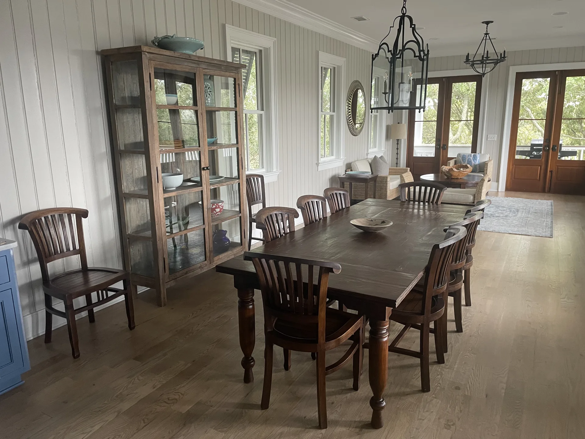 Blue kitchen island with dark wood bar stools and modern pendant light