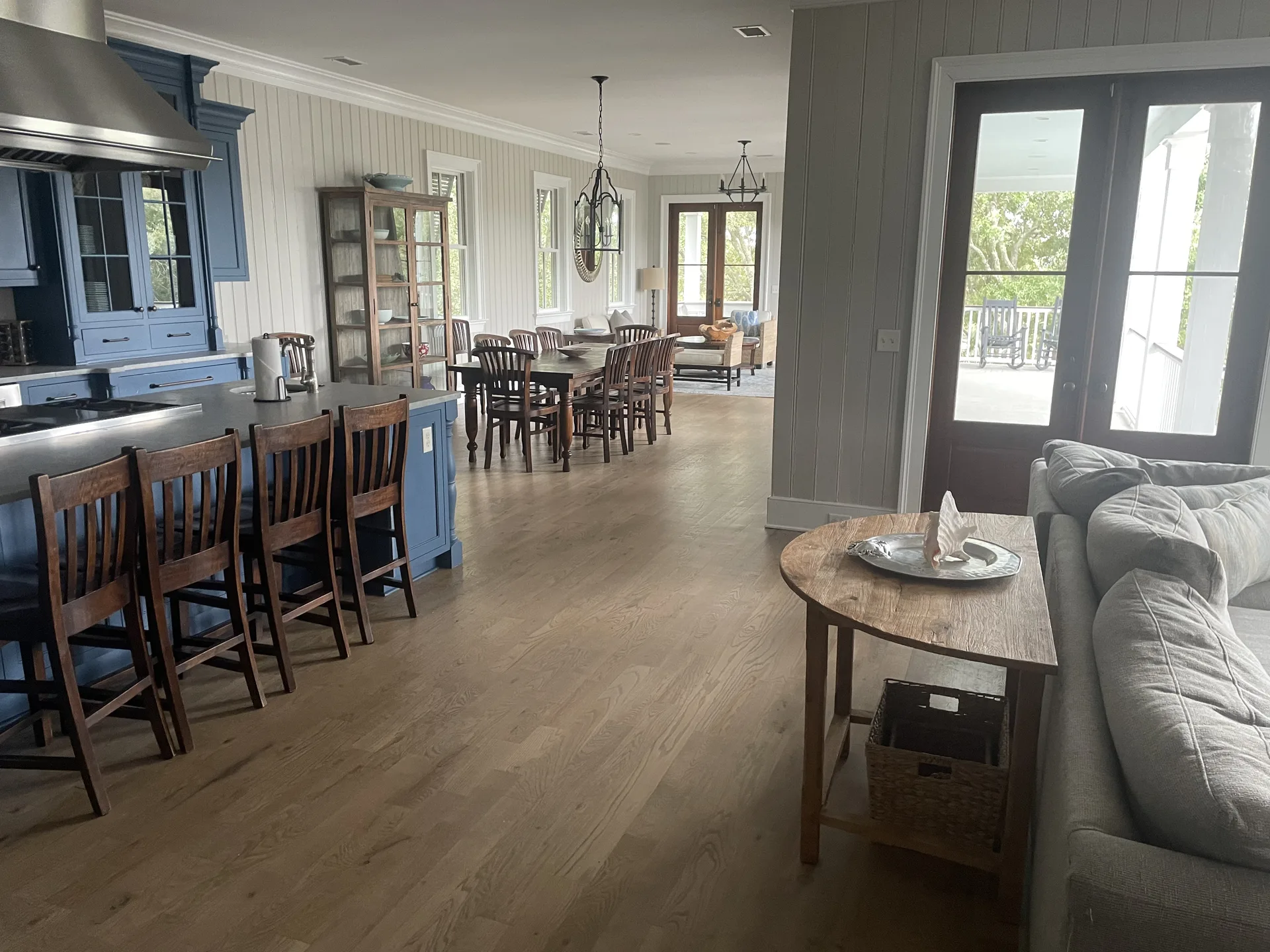 Stunning open kitchen with blue island, bar seating, dining area, and chandelier