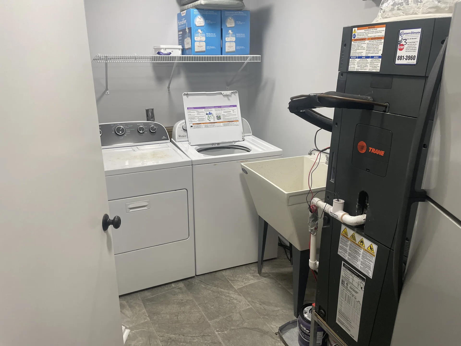 Full-size washer and dryer in dedicated laundry room with utility sink