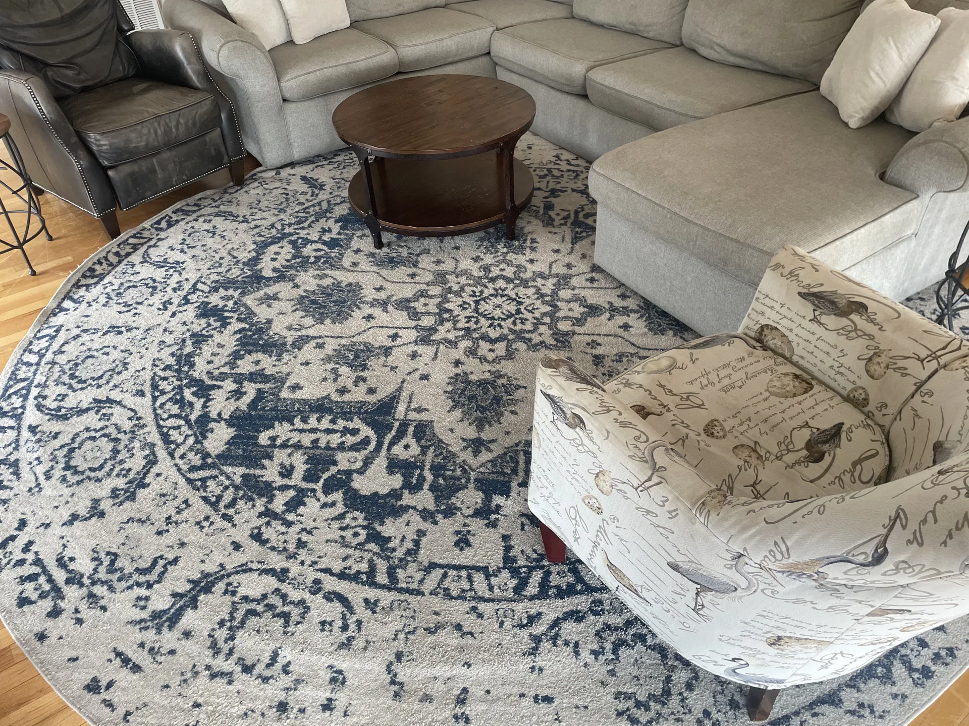 Upper level living room with comfortable seating, area rug, and natural light