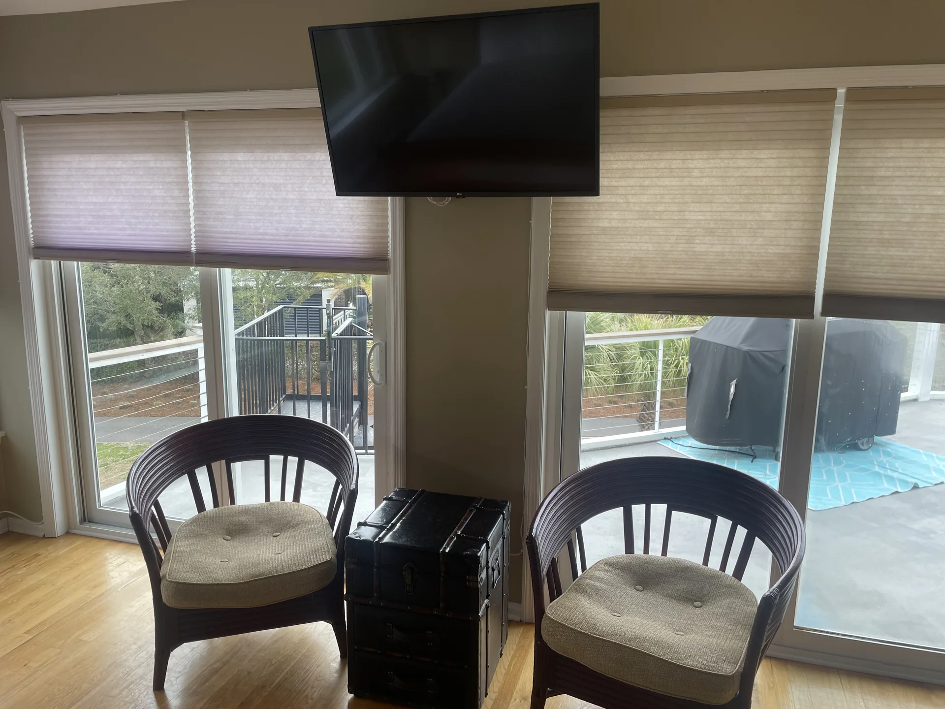 Sitting nook with two chairs, wall-mounted TV, and deck with pool view